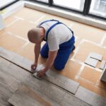 Person installing laminate flooring panels near Breese, IL