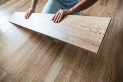 Man holding a floorboard as he is reflooring a hardwood floor at Preferred Flooring near Breese, IL