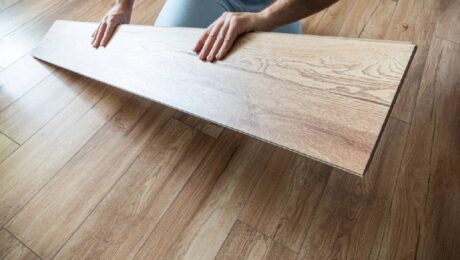 Man holding a floorboard as he is reflooring a hardwood floor at Preferred Flooring near Breese, IL