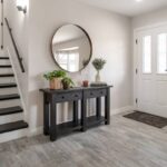 An entry hallway with a console table displaying decorative items and a mirror hanging above at Preferred Flooring near Breese, IL