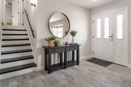 An entry hallway with a console table displaying decorative items and a mirror hanging above at Preferred Flooring near Breese, IL