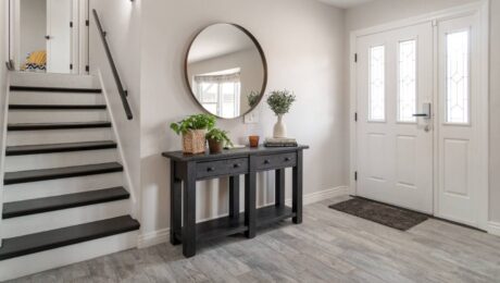 An entry hallway with a console table displaying decorative items and a mirror hanging above at Preferred Flooring near Breese, IL