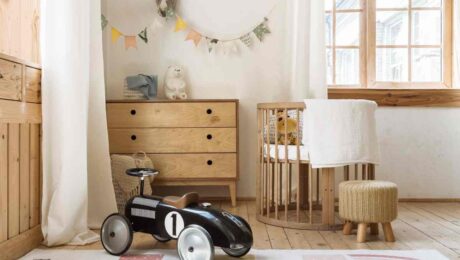 Light hardwood floors in a nursery with a hopscotch area rug and racecar riding toy near Breese, IL